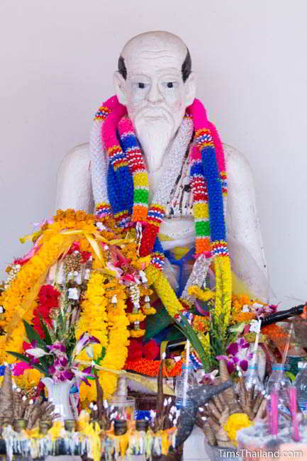 Statue of man covered in garlands at fifth Khon Kaen city pillar shrine, at Ban Thum