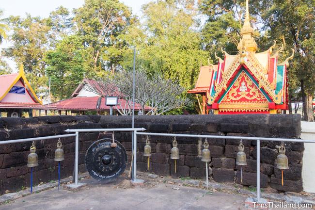 Bells and gone alongside laterite enclosure at Ku Sunthararam Khmer Ruin