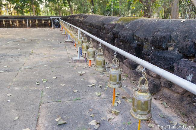 Bells alongside laterite enclosure at Ku Sunthararam Khmer Ruin