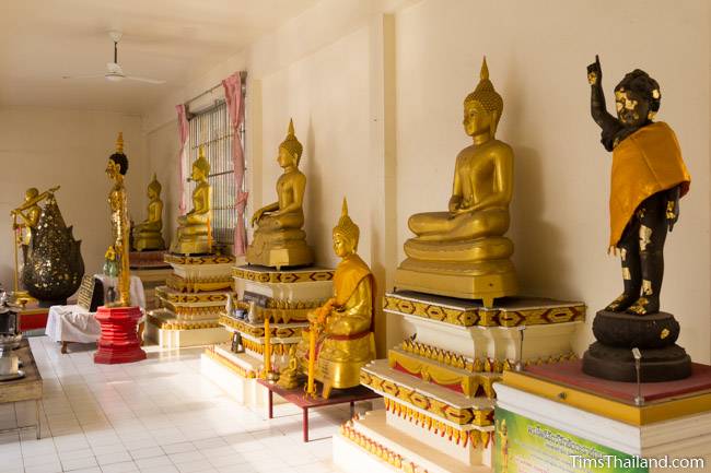 Buddha images in cloister around the stupa at Wat That