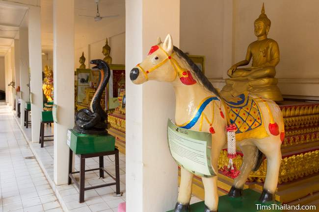 Buddhas and zodiac animals in cloister around the stupa at Wat That