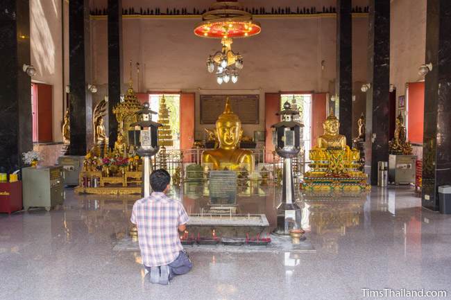 man praying before Luang Por Phra Phut Buddha image