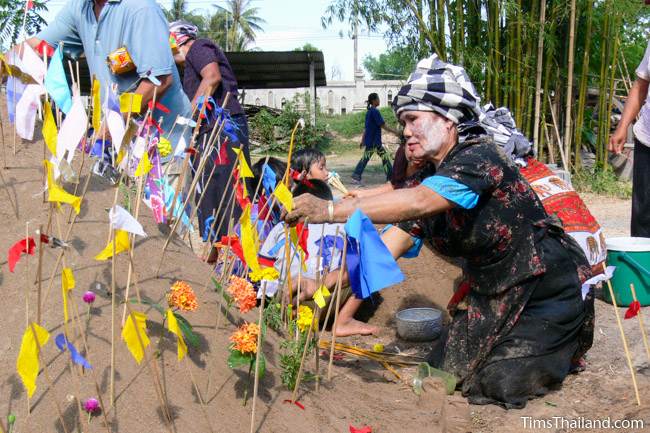 woman putting flags on sand castle during Songkran