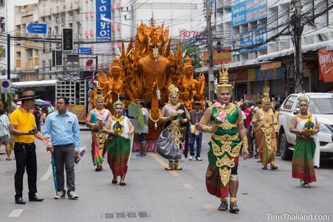 Khao Phansa candle parade float driving down the street with costumed dancers walking in front