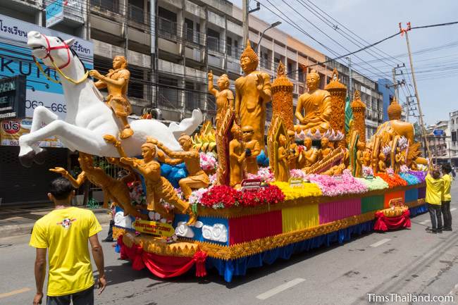 Khao Phansa candle parade float with a white horse driving down the street