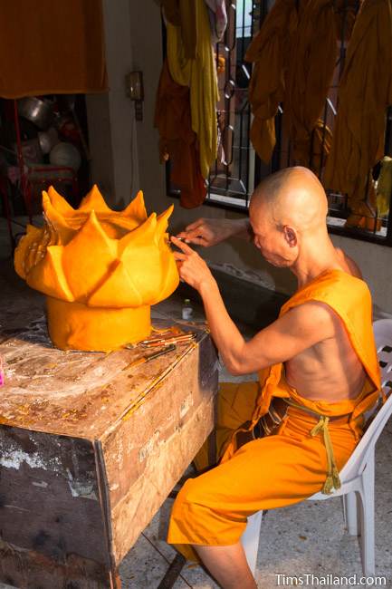 monk carving a part of a Khao Phansa candle parade float