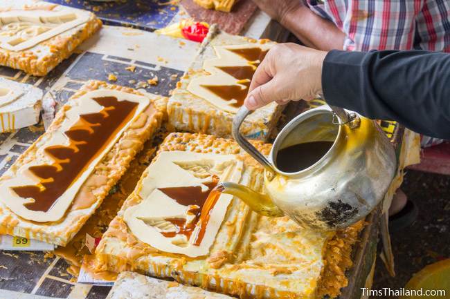 pouring wax into a silicon mold for a Khao Phansa candle parade float