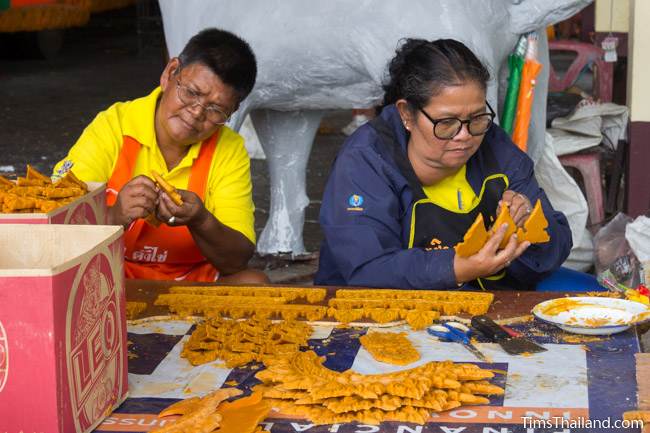 women carving wax pieces for a Khao Phansa candle parade float