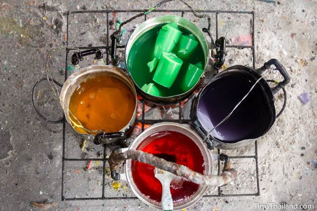 colored wax being melted for a Khao Phansa candle parade float