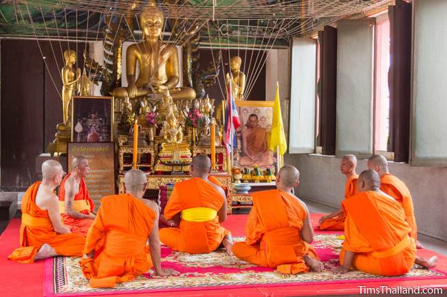 monks in front of a large Buddha