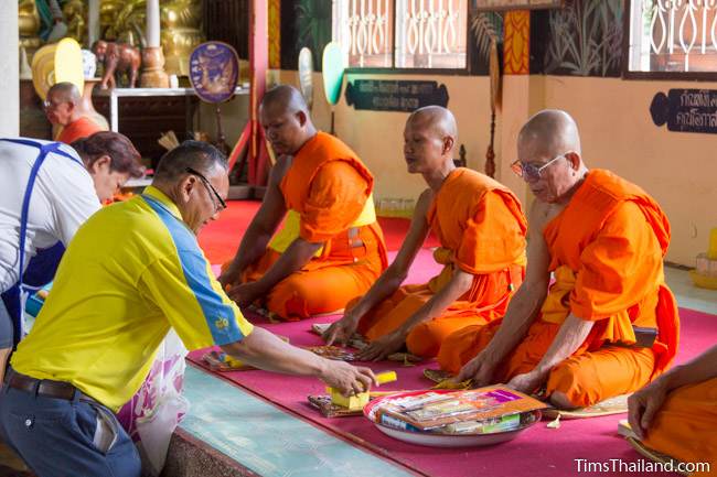 people making offerings to monks