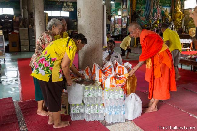 people making offerings to a monk