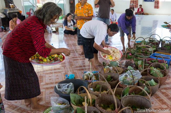 women putting food into wicker baskets