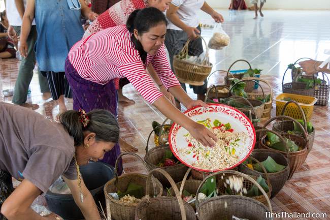 women putting food into wicker baskets