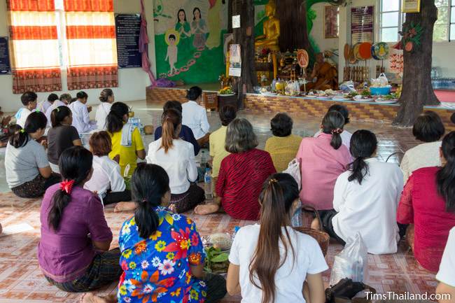 people listening to a monk preaching