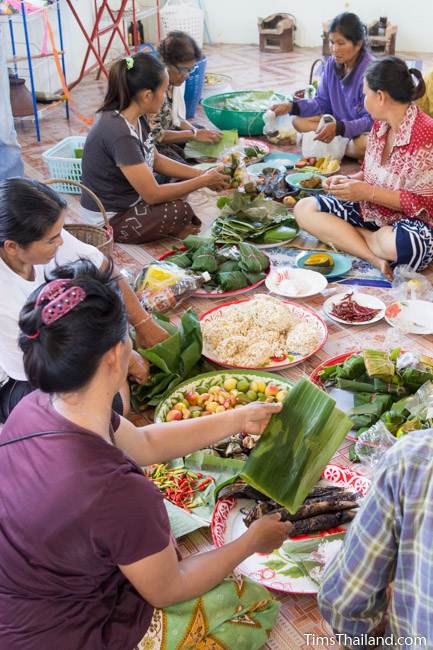 women unwrapping food from banana-leaf wrappers