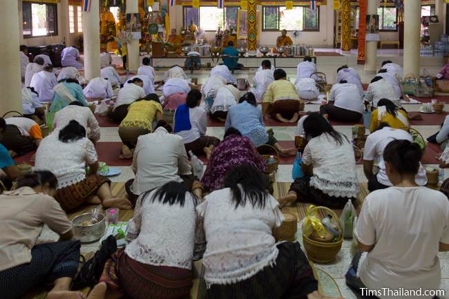 people bowing before monks in the temple during Boon Khao Pradap Din