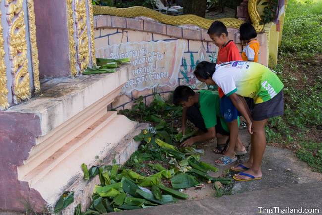 kids looking for coins in food packets during Boon Khao Pradap Din