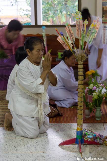 donating money at the temple during Boon Khao Pradap Din
