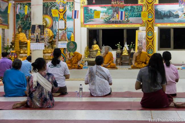 people sitting in front of monks at night during Boon Khao Pradap Din