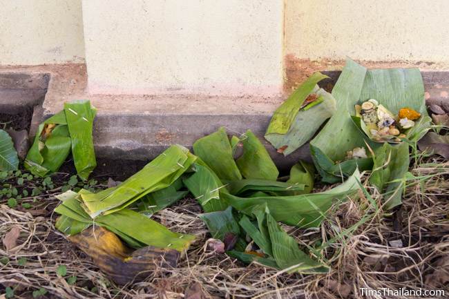 food packets laying along the temple boundary wall during Boon Khao Pradap Din