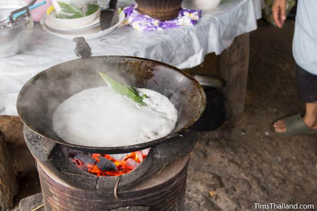 cooking khao tom pat in wok during Boon Khao Pradap Din