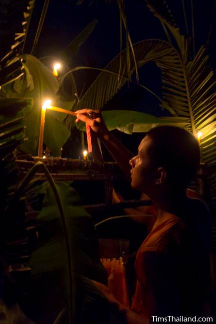 monk lighting candles during Ok Phansa