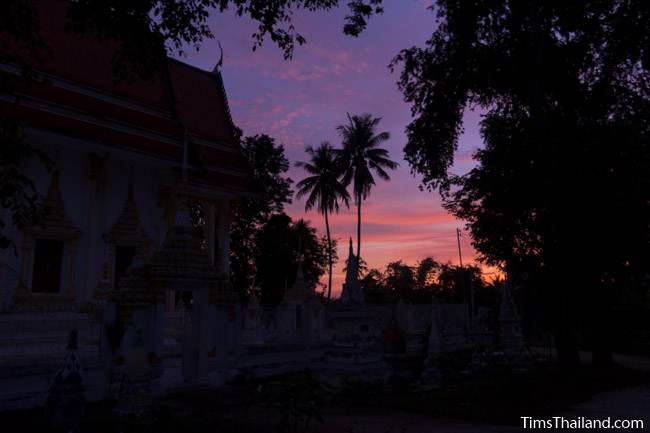 sunrise behind temple building during Ok Phansa