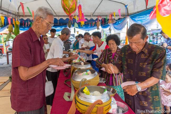 putting food in monk bowls for Kathin celebration