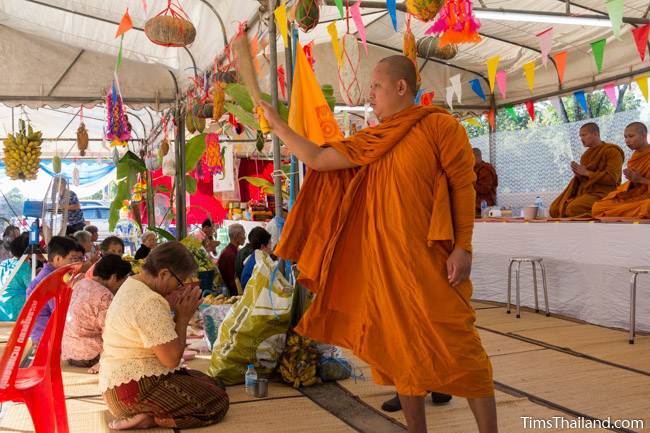 monk splashing water on people for a blessing for Kathin celebration