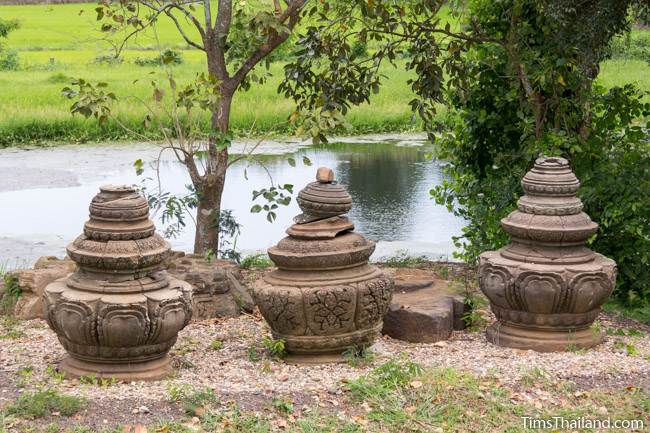 three lotus-bud tops at Prang Phakho Khmer ruin with moat in background