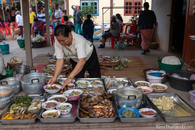 putting food for monks on plates at Boon Berk Bahn