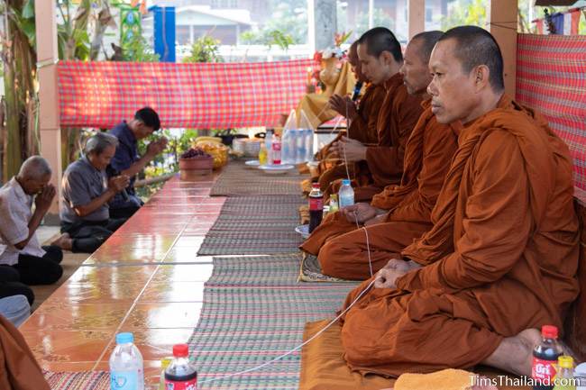 monks holding sacred thread at Boon Berk Bahn