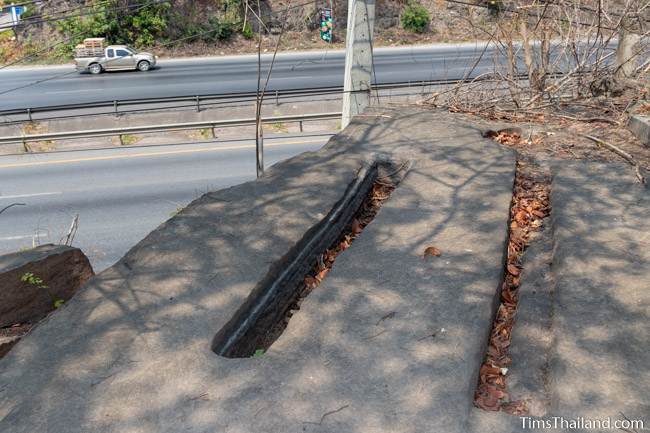 shallow grooves cut into sandstone next to highway