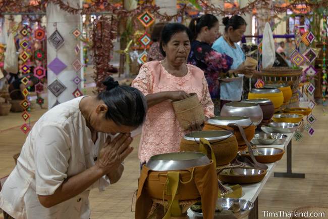 putting rice in monks bowls