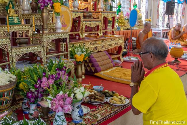 man praying in front of Buddha statue