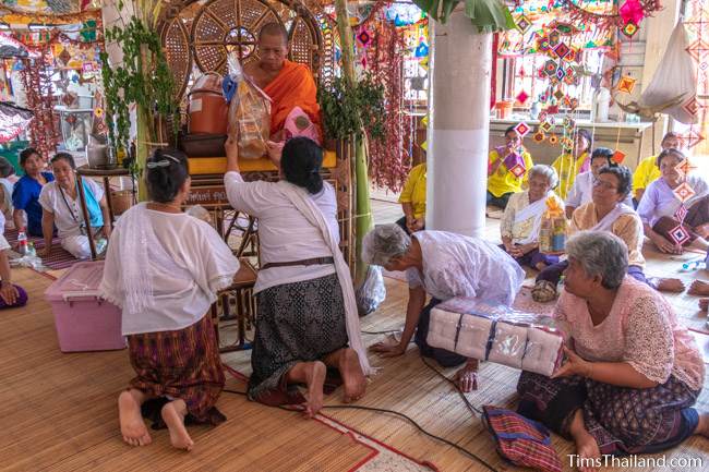 women giving gifts to a monk