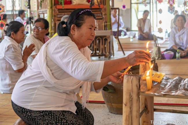 woman lighting a candle in the wihan