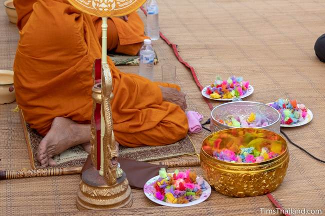 bowls of coins next to a monk