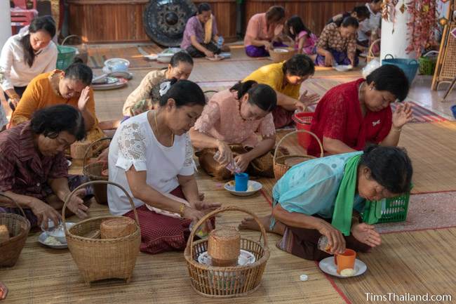 people at temple pouring water into cups and bowls