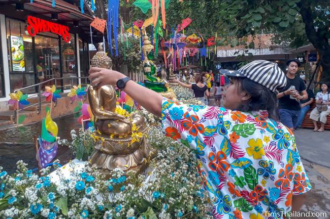 pouring water over a Buddha at a shopping mall