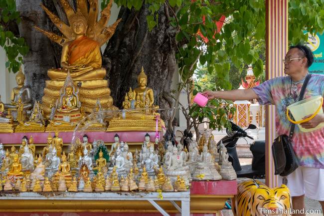 pouring water on Buddhas at temple