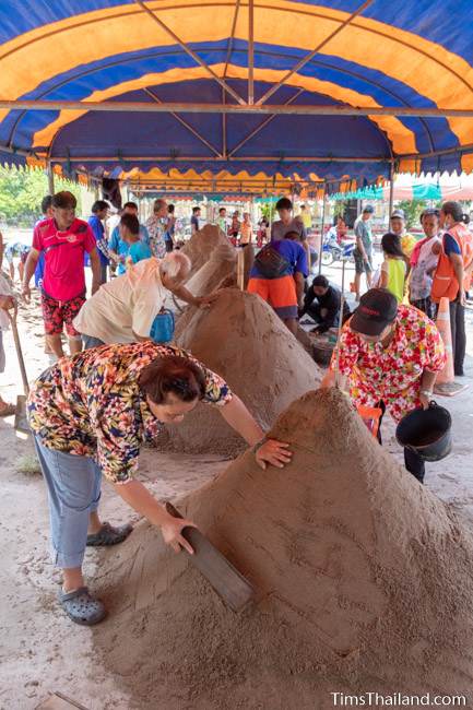 people building sand stupas