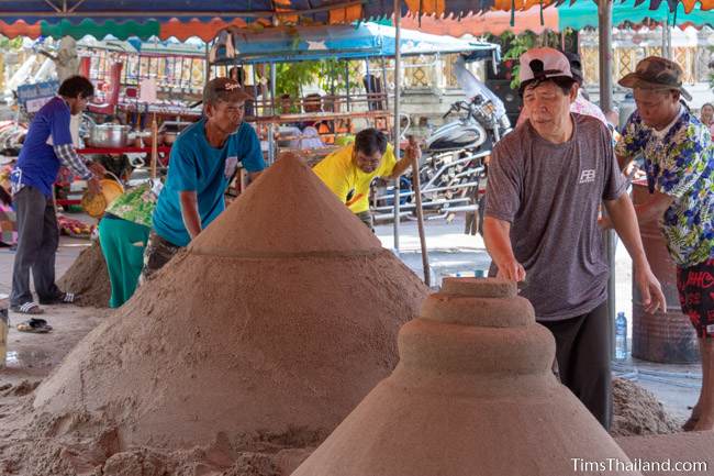 people building sand stupas