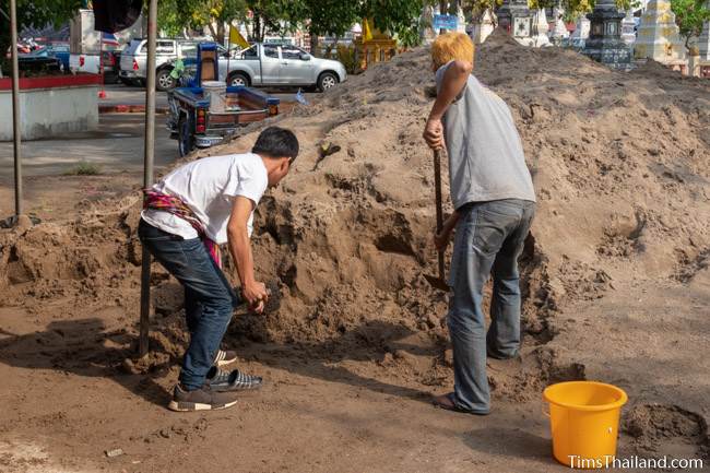 digging sand out of large pile