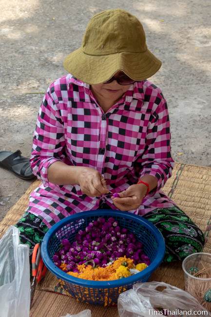 woman preparing flowers for sand stupas