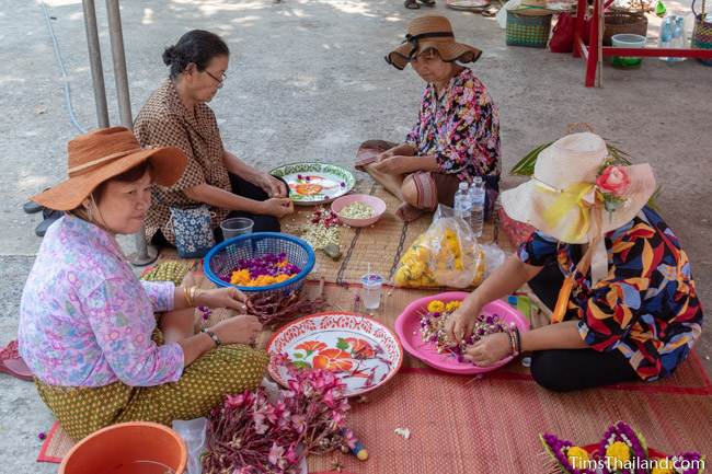 women preparing flowers for sand stupas