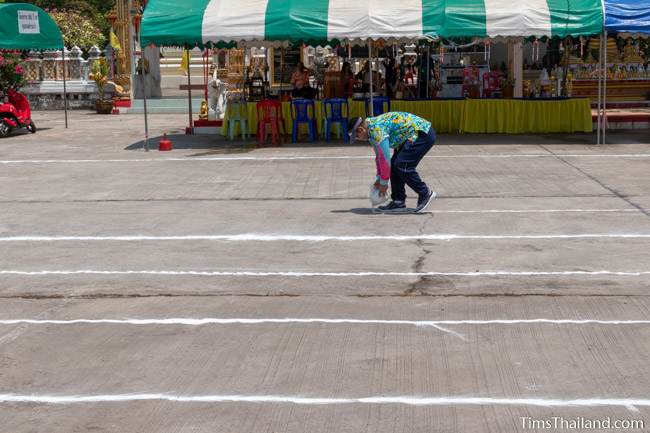 man putting chalk on the group to make a racetrack