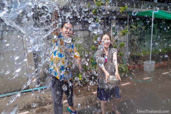 children throwing water at the photographer