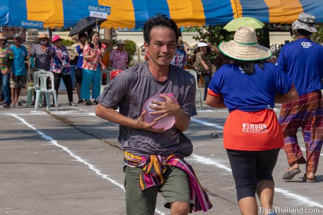 man running with a water balloon